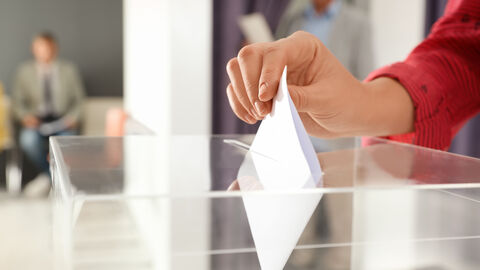 Darstellung eines Stimmzetteleinwurfs in eine gläserne Wahlurne Darstellung eines Stimmzetteleinwurfs in eine gläserne Wahlurne